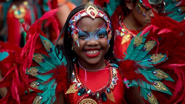 Close up of a girl in bright carnival colours at Families and Childrens Day at Notting Hill Carnival